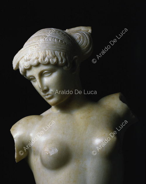 Venus (posiblemente Cleopatra) desnuda en el acto de atarse el pelo flanqueada por un jarrón decorado con una cobra que descansa sobre una cesta floral venus