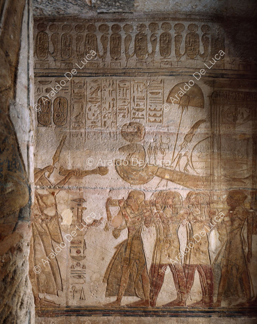 Ramses opfert Weihrauch und das Zepter der Macht vor dem Boot des Amun-Ra in Anwesenheit von Nefertari, die die Zepter schüttelt