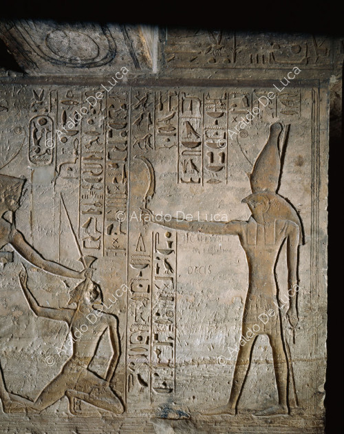 Rameses II massacres a Libyan in front of Horus