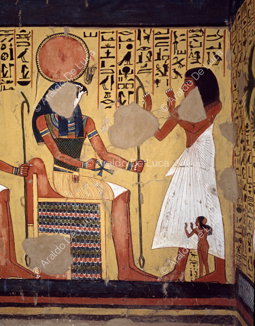 Escena en la pared derecha de la cámara funeraria. La escena muestra al difunto y a una niña adorando a varios dioses: Ra-Harakhty, Atum, Knepri y Ptah, que están sentados. El detalle muestra a la pareja adorando a Ra-Harakhty.
