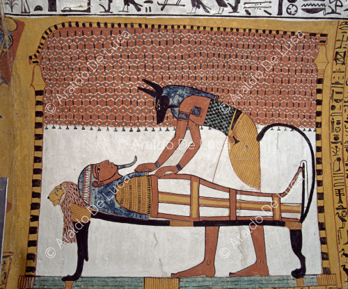 Bajo un elaborado dosel, la momia de Sennedjem es depositada y compuesta por el dios Anubis en un lecho zoomorfo con cabeza, patas y cola de león.