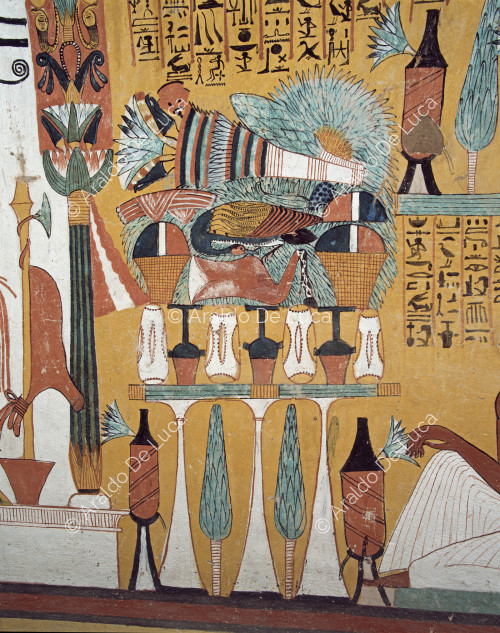 Detalle de la mesa de ofrendas llena de alimentos y vasijas colocada ante el dios Osiris.
