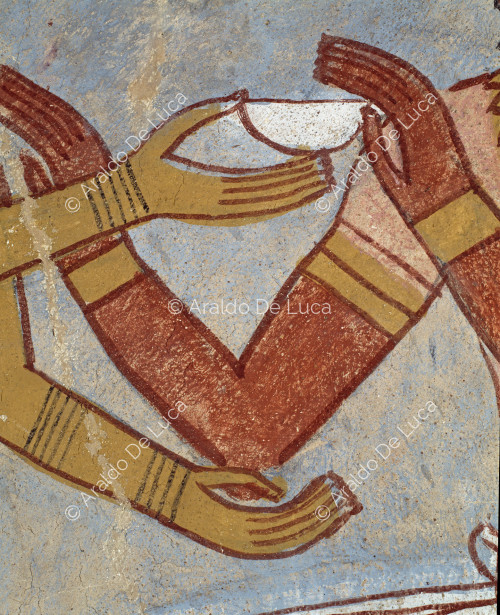 Detalle que muestra el intercambio de un cuenco de libación (nb) de un par de brazos femeninos (caracterizados por su color amarillo claro) por dos masculinos (ocre oscuro).